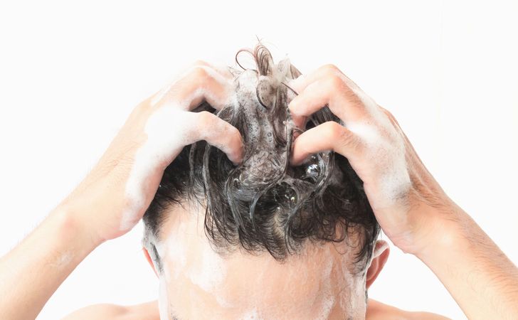 男性が髪の毛を洗っている姿